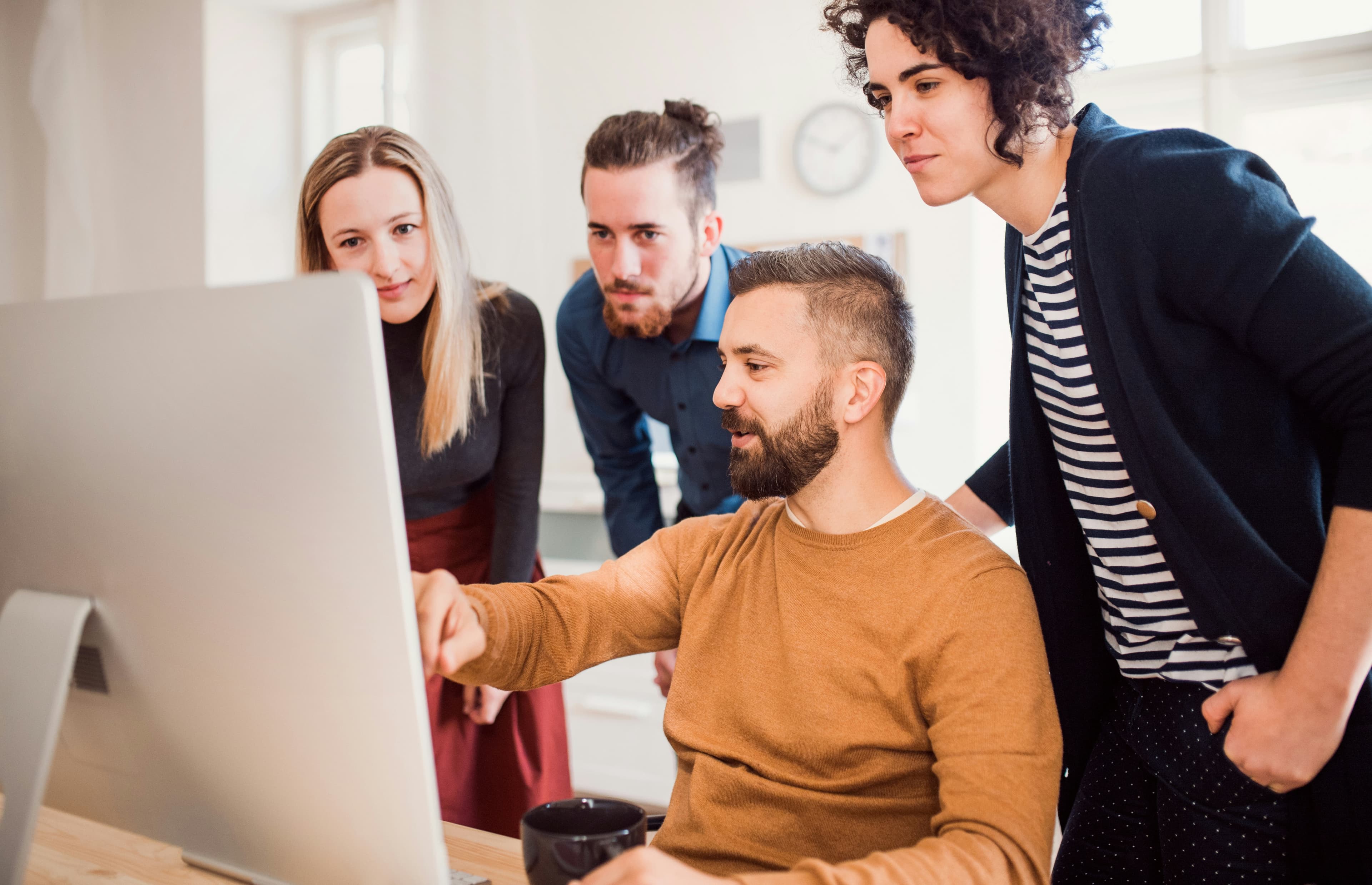 Team collaborating around a screen